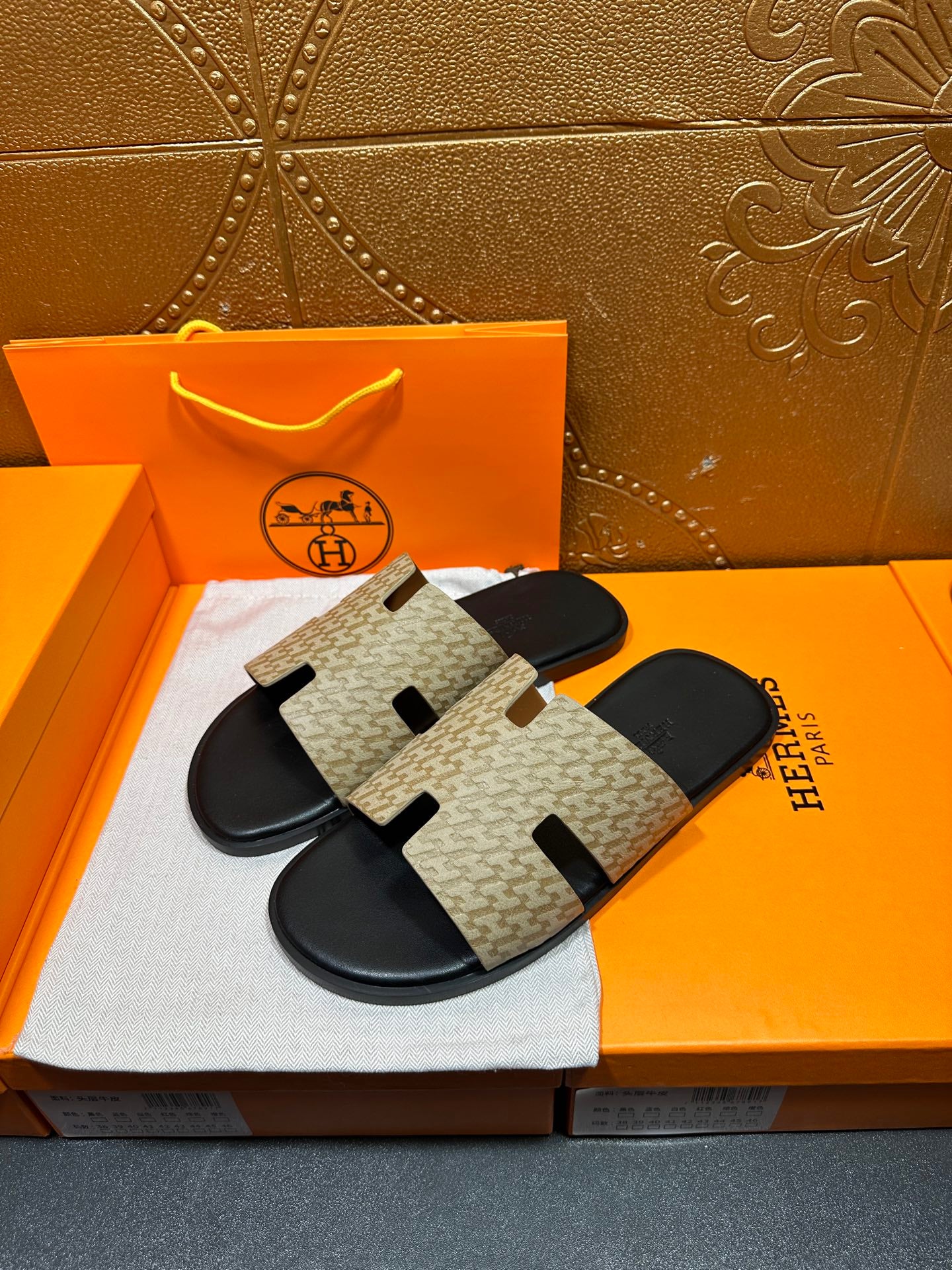 Beige patterned slide sandals with two black strap cutouts and black footbed