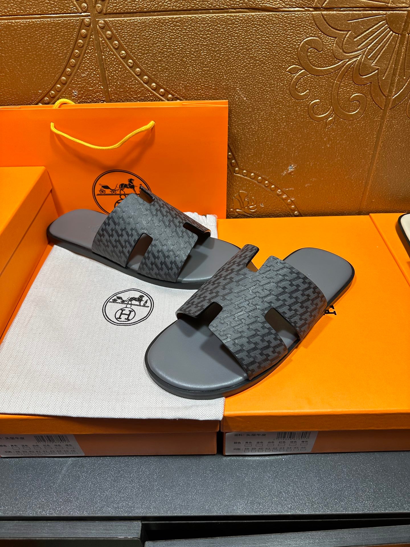 Hermes slide sandals pair, two-quarter view, dark patterned fabric with black rubber soles