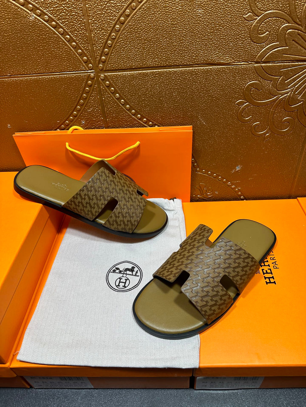 Hermes slide sandals on box: open-toe patterned straps with olive-green footbeds