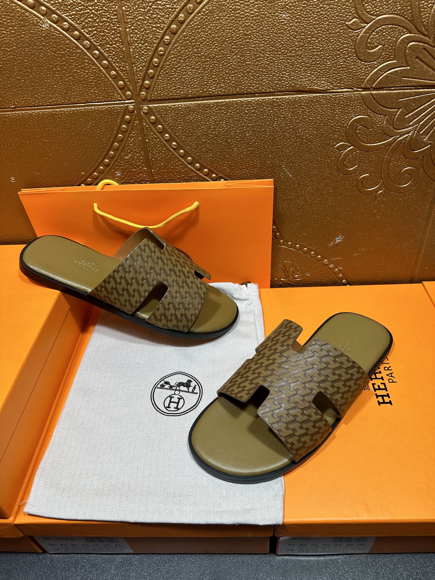 Hermes slide sandals on box: open-toe patterned straps with olive-green footbeds