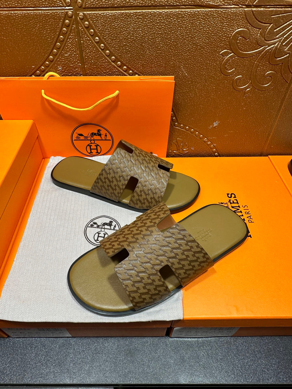 Hermes slide sandals with patterned cross-strap design and olive-green rubber footbeds