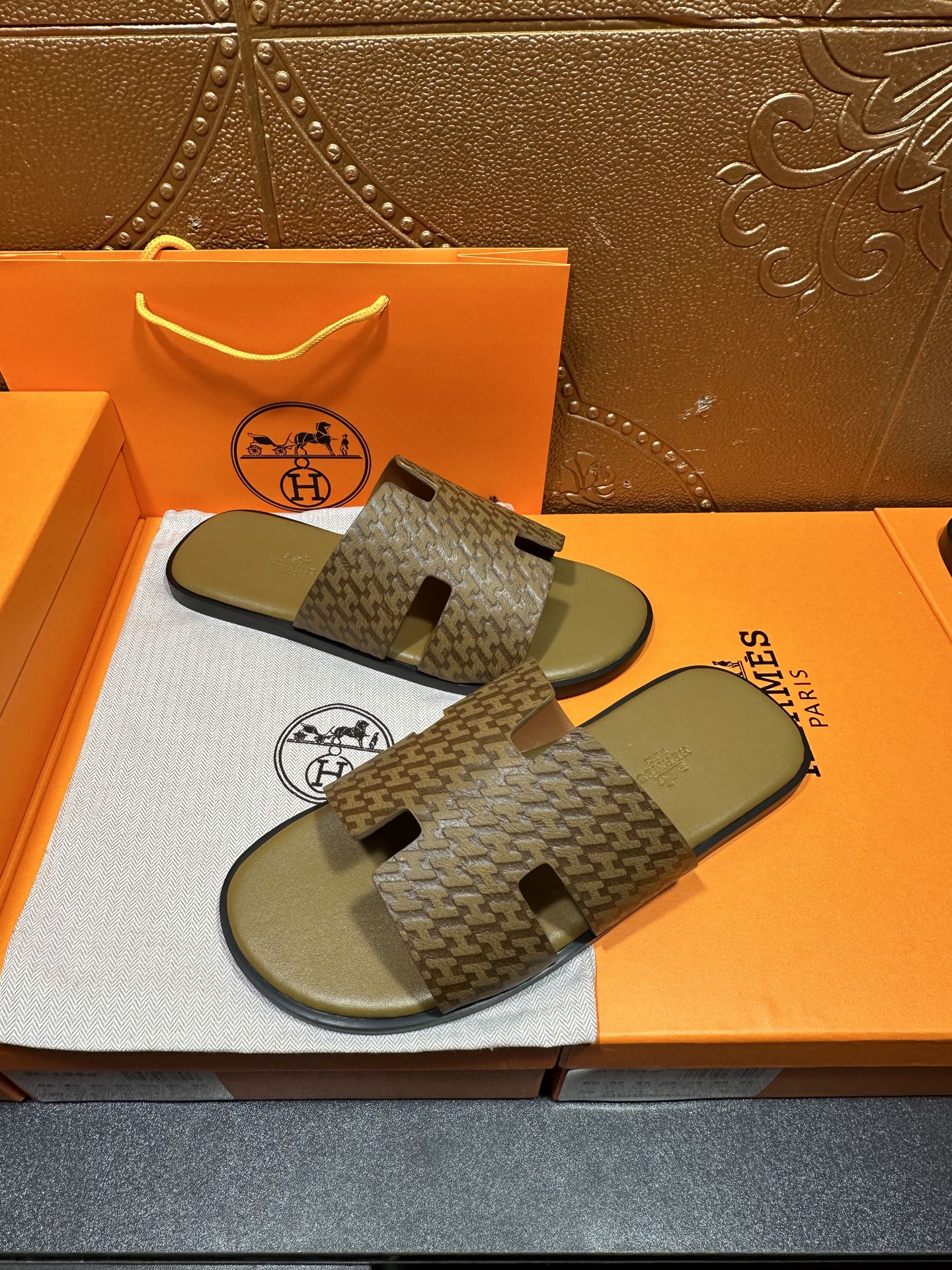 Hermes slide sandals with patterned cross-strap design and olive-green rubber footbeds