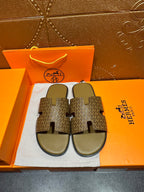 Hermes slide sandals with textured tan-and-brown patterned straps and light green footbeds