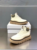White lace-up sneakers with chunky sole, shown front and side angles on box