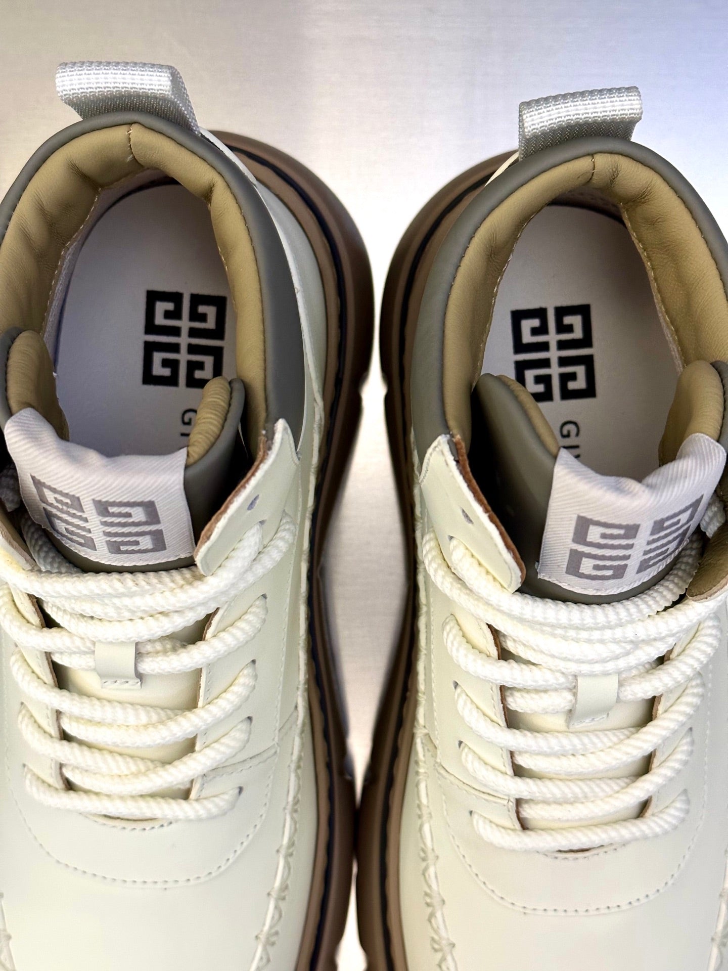 Givenchy sneakers close-up: off-white uppers with laces and logo-lined interior