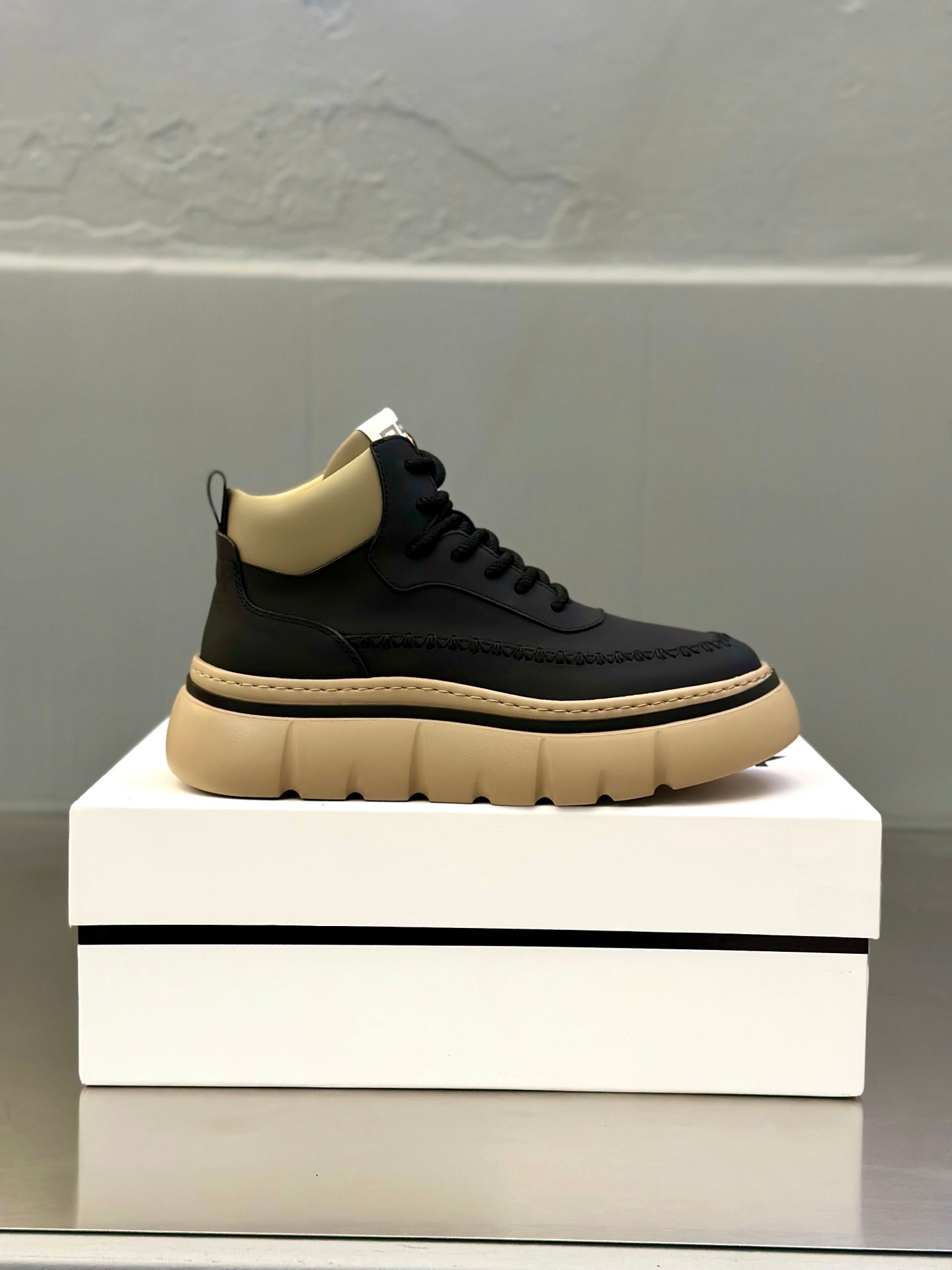 Dark lace-up sneakers with beige panel at collar and thick light platform sole.