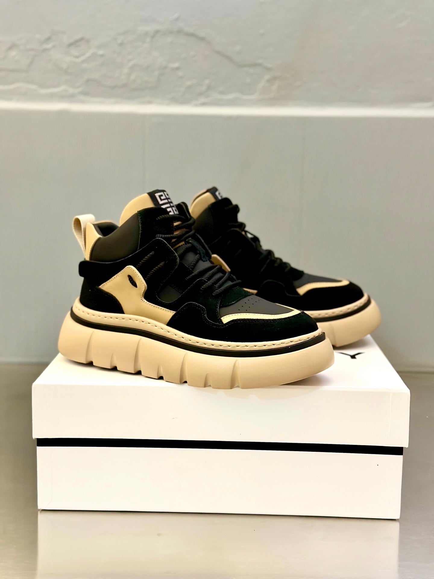 Black and beige lace-up sneakers, angled view with contrast trim and chunky sole.
