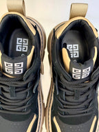 Close-up of black and beige sneaker interior lining with geometric logo on tongue.