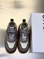 Pair of sneakers in gray, white, and cream with lace-up fronts and chunky rubber soles