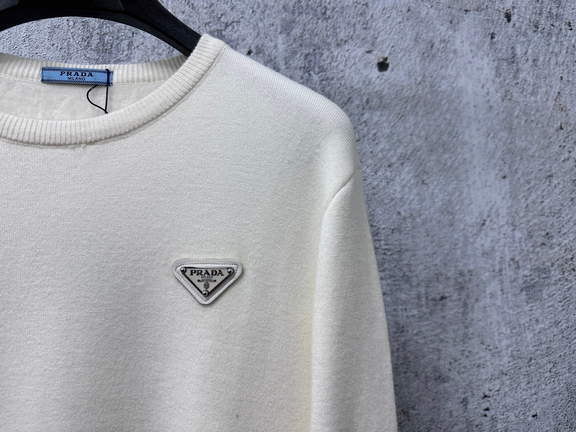 Prada cream sweater with small triangle PRADA logo at upper left chest