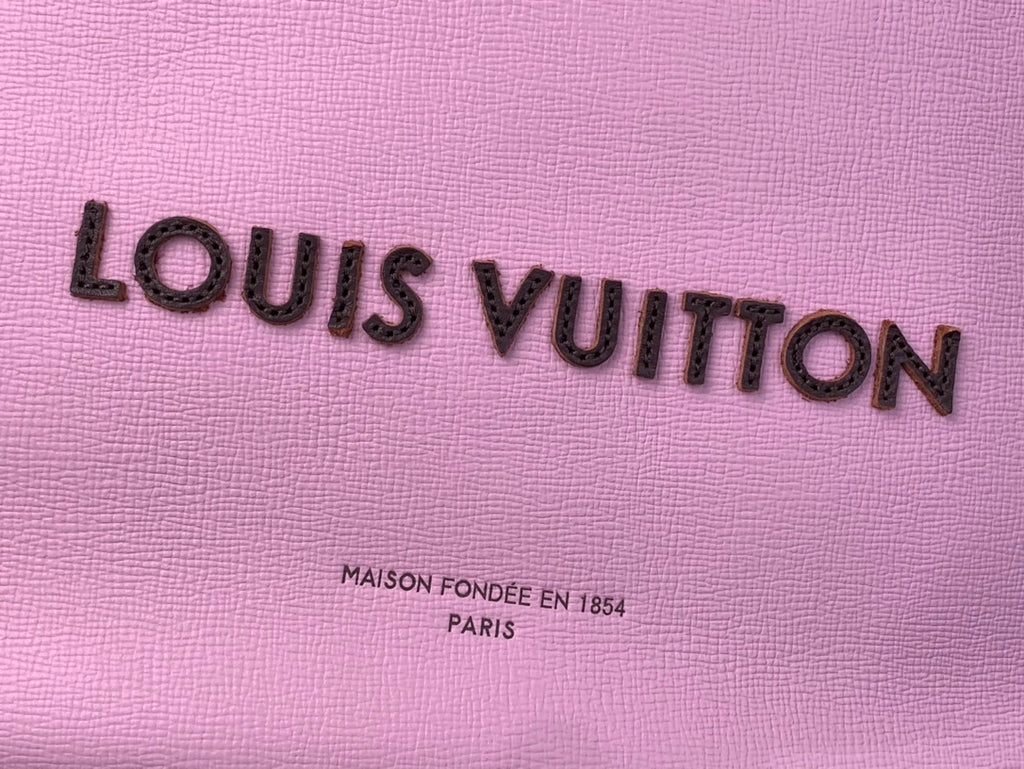 Louis Vuitton logo on textured pink leather bag, with “Maison fondée” text