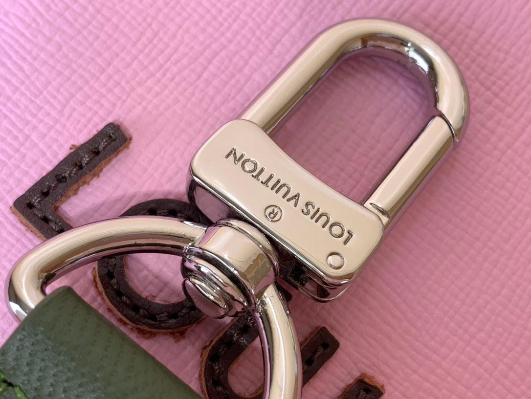 Louis Vuitton bag with green eyelet hardware and pink leather strap base
