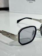 Clear-lens sunglasses with black-tinted frames and silver logo temples