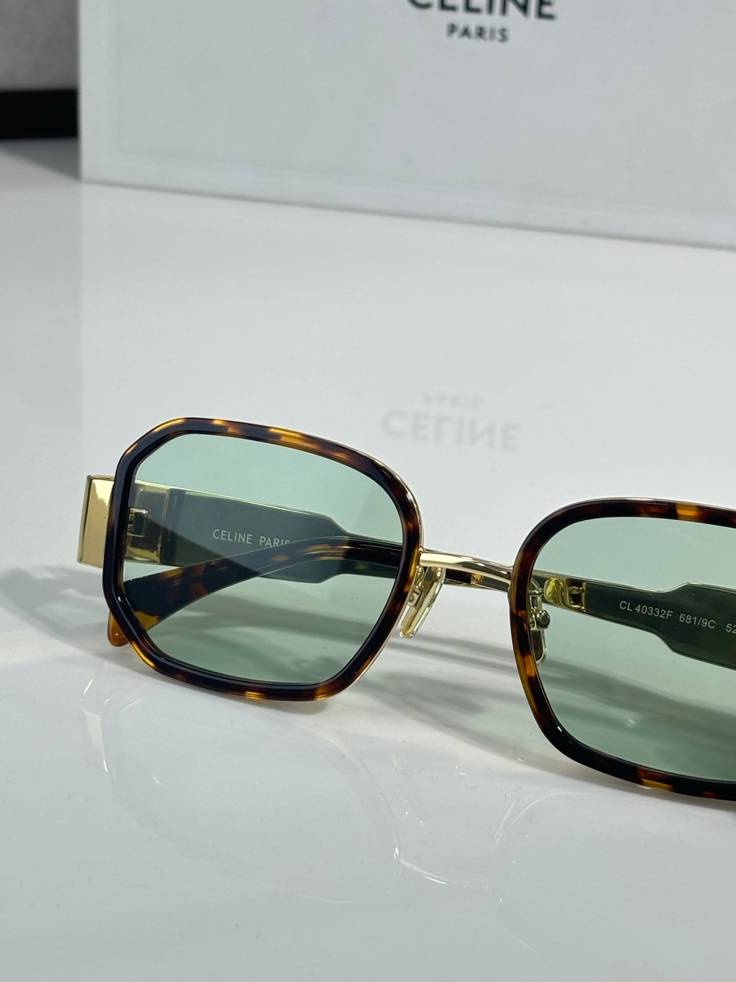 Tortoise sunglasses with gold-tone rim and green-tinted lenses, square style