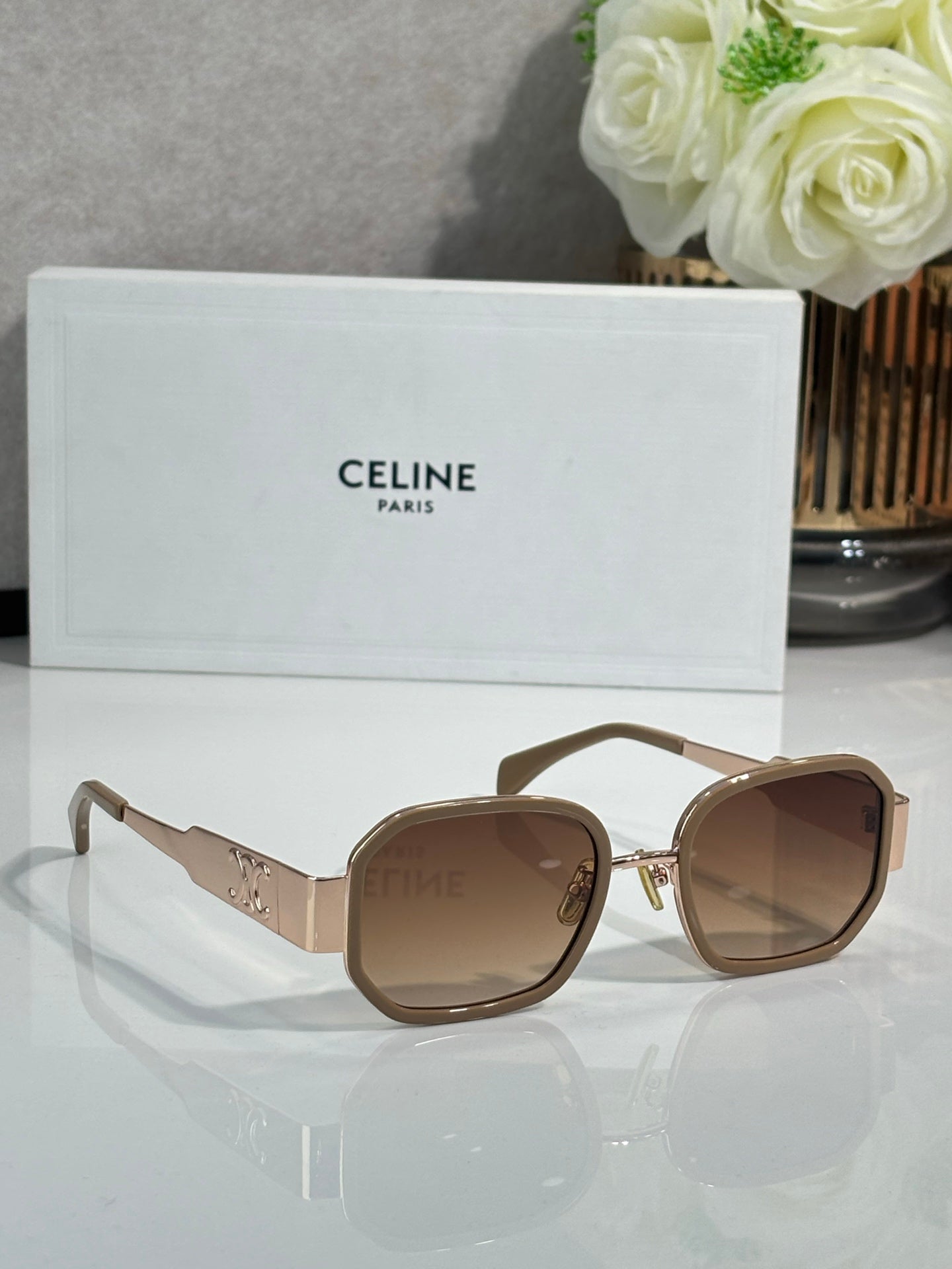 Brown sunglasses with wide round frames, gold-tone hinges, tinted lenses