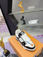 Louis Vuitton ladies sneakers on orange box, white panels with black side stripes and laces.