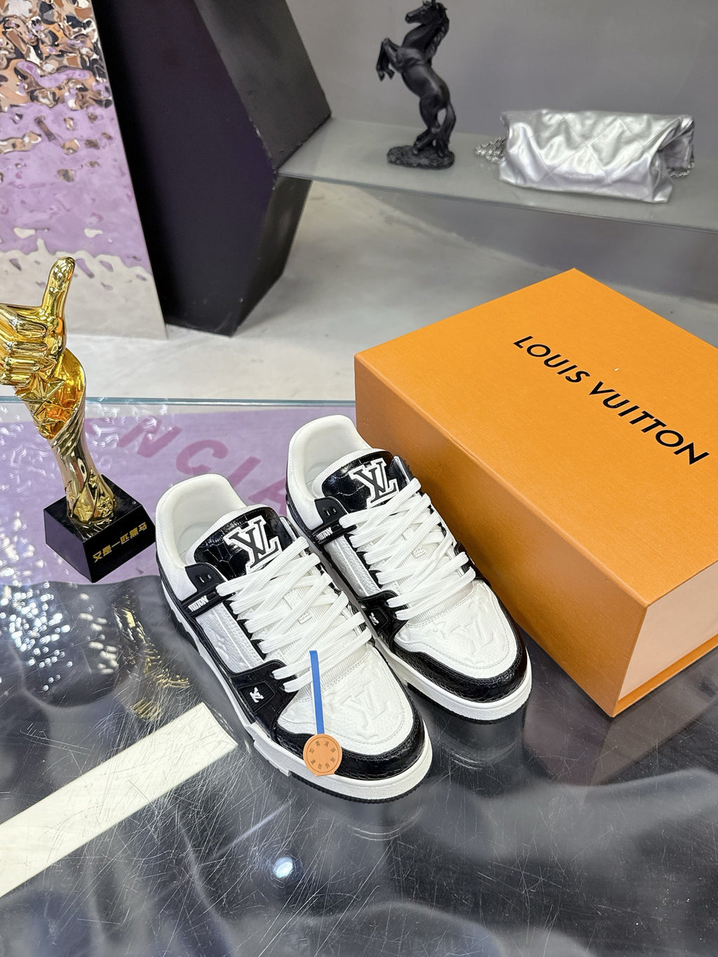 Louis Vuitton ladies sneakers on orange box, front view with black-and-white upper details.