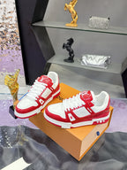 Louis Vuitton red-and-white low-top sneakers paired on a tan display box