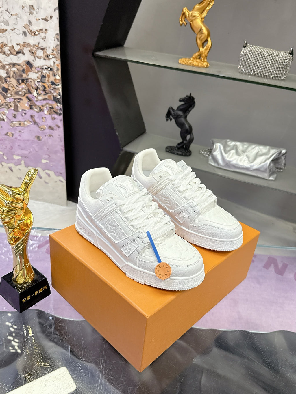 Louis Vuitton women's white lace sneakers on orange box, side view