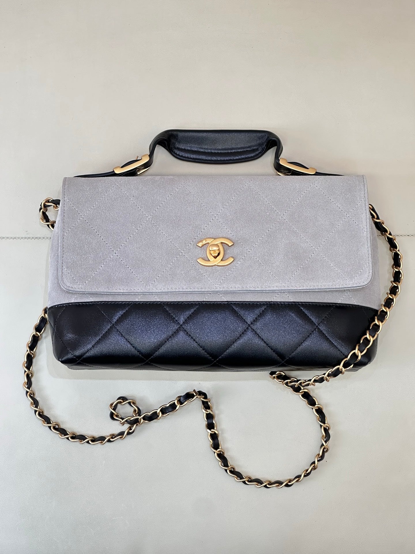 Chanel shoulder bag with light gray flap, navy quilted front band, gold chain strap