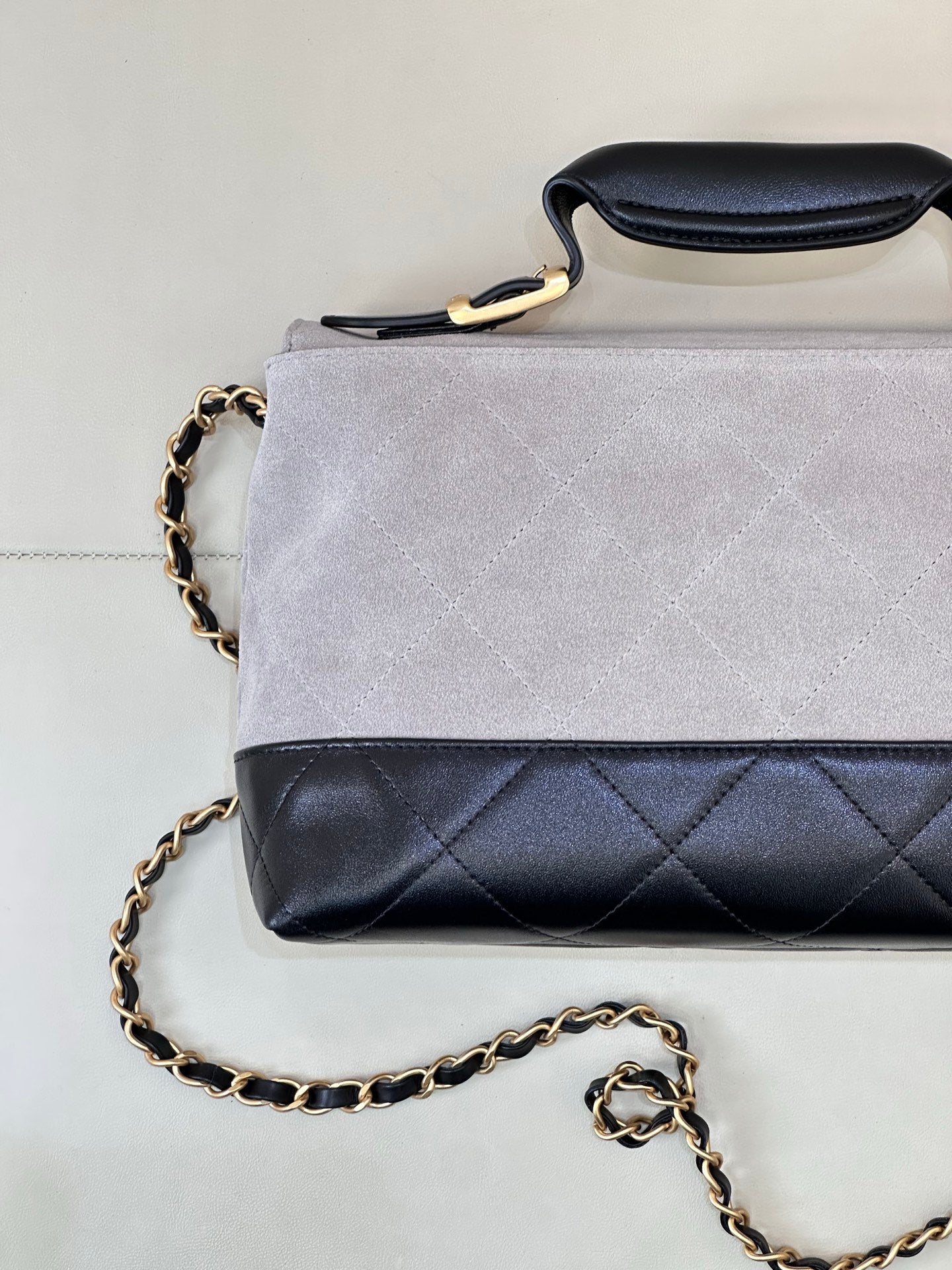 Chanel small crossbody bag with light gray suede-look flap and dark navy quilted section