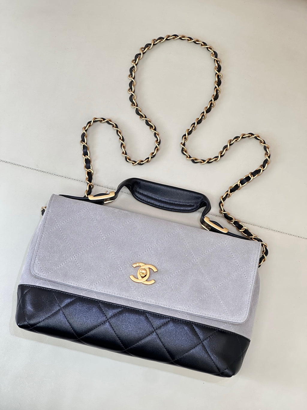 Chanel crossbody bag with light gray flap, dark navy quilted panel, gold-tone chain strap