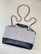Chanel crossbody bag with light gray flap, dark navy quilted panel, gold-tone chain strap