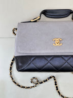 Chanel flap handbag with light gray front and dark navy quilted base, gold chain strap