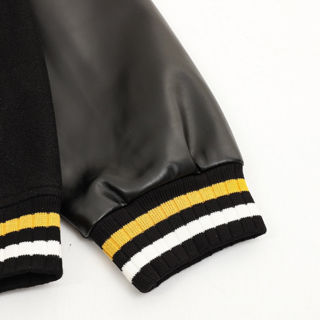 Black leather-look sleeve cuff with ribbed yellow/white stripes at the wrist
