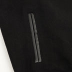Black varsity jacket with vertical side pocket seam detail