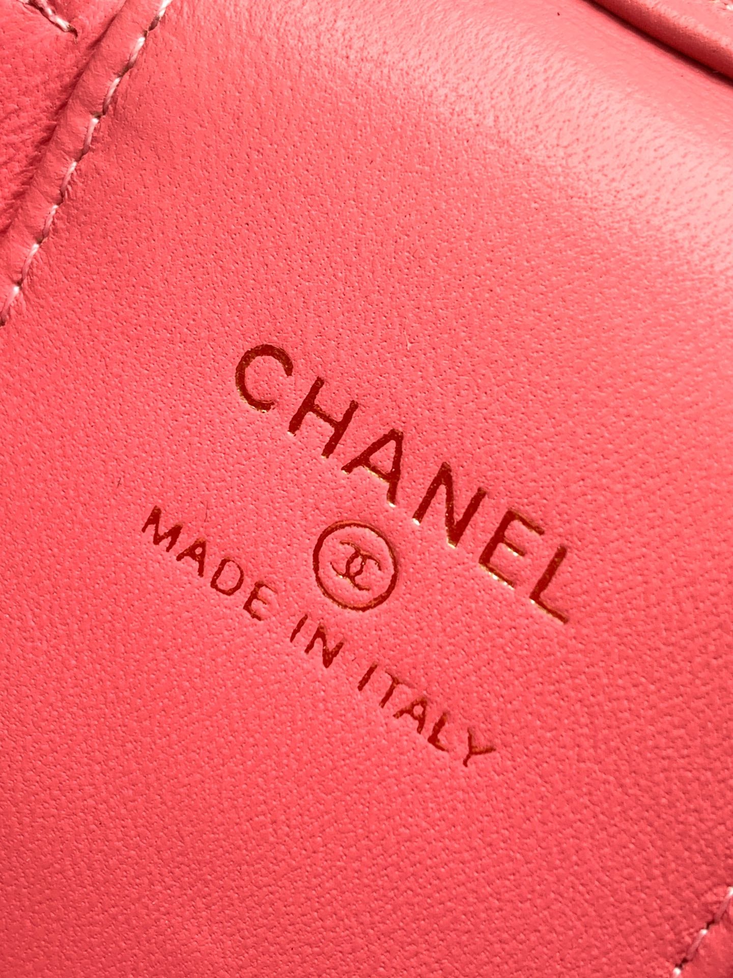 Pink leather bag close-up showing 'Chanel' and 'Made in Italy' stamp