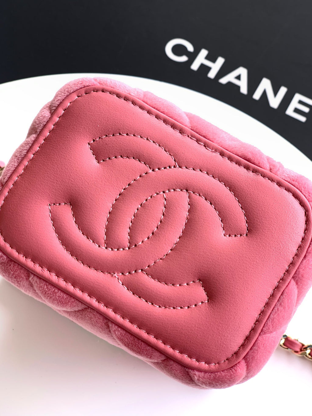 Pink mini bag close-up with embossed CC logo on quilted leather