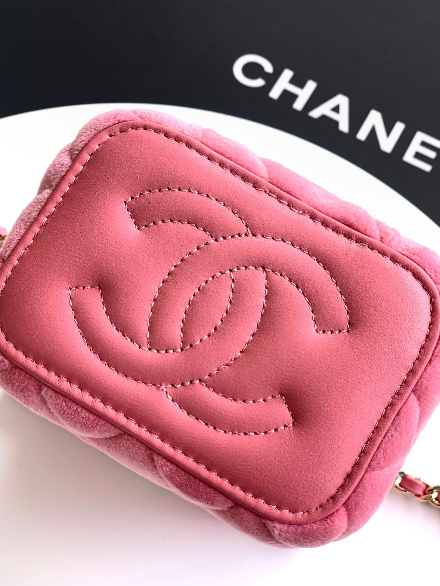 Pink mini bag close-up with embossed CC logo on quilted leather