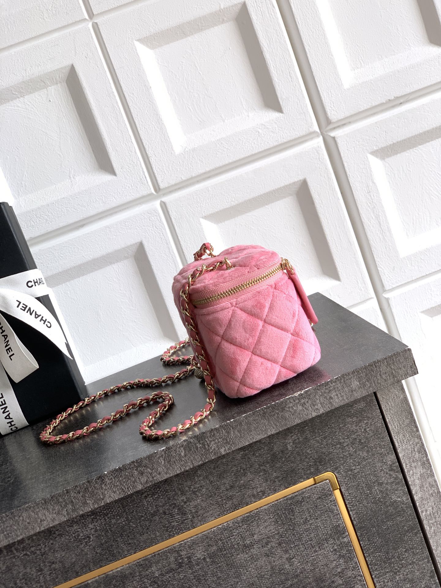 Pink quilted crossbody mini bag with gold-tone chain strap and zipper top
