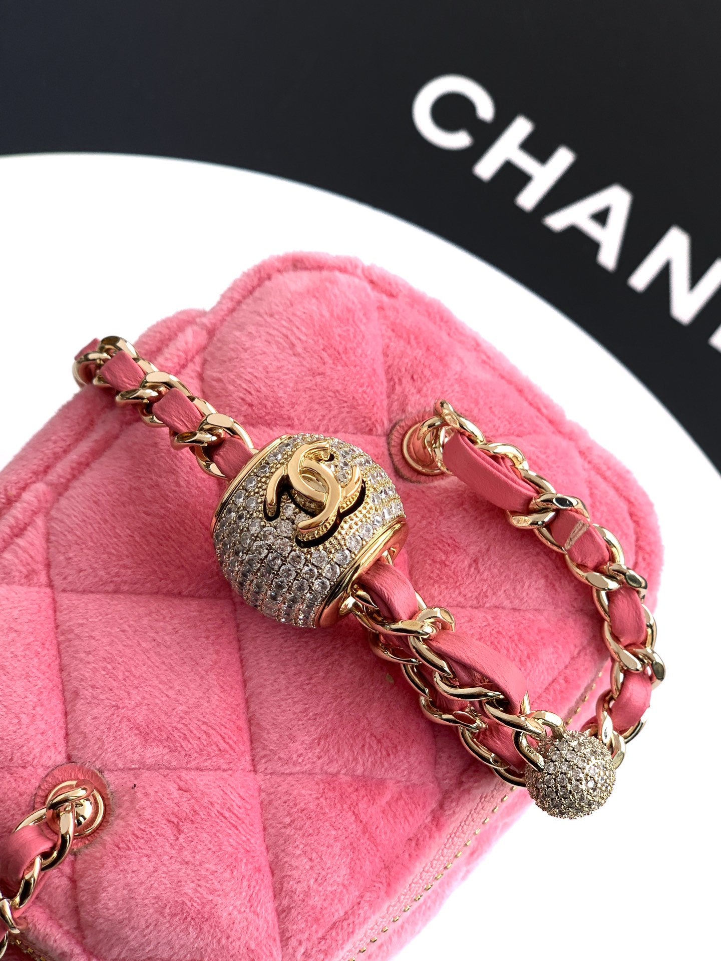 Pink mini bag close-up with gold-tone chain and dangling charm accents