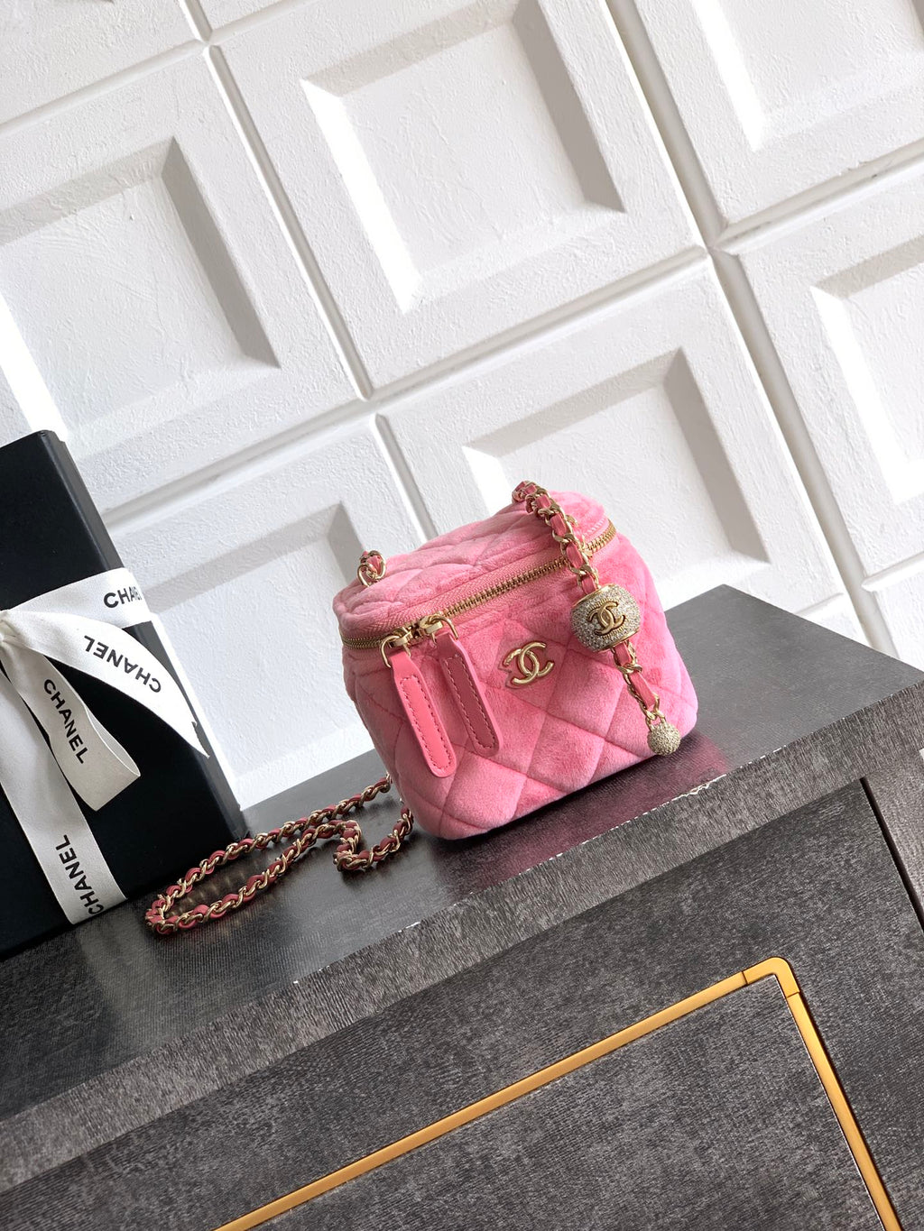 Pink quilted mini bag with gold-tone chain strap and top zipper closure