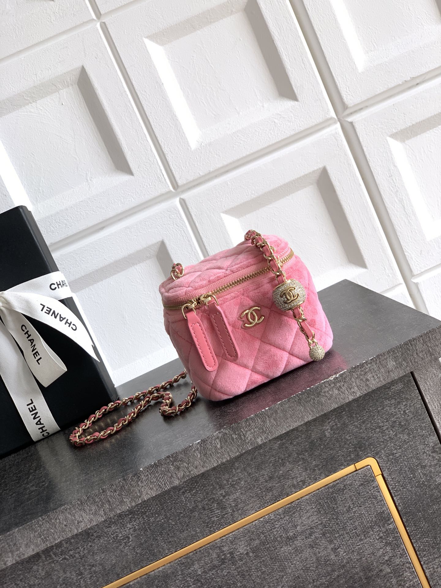 Pink quilted mini bag with gold-tone chain strap and top zipper closure