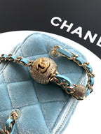 Chanel light blue quilted bag close-up with ornate gold charm and chain strap