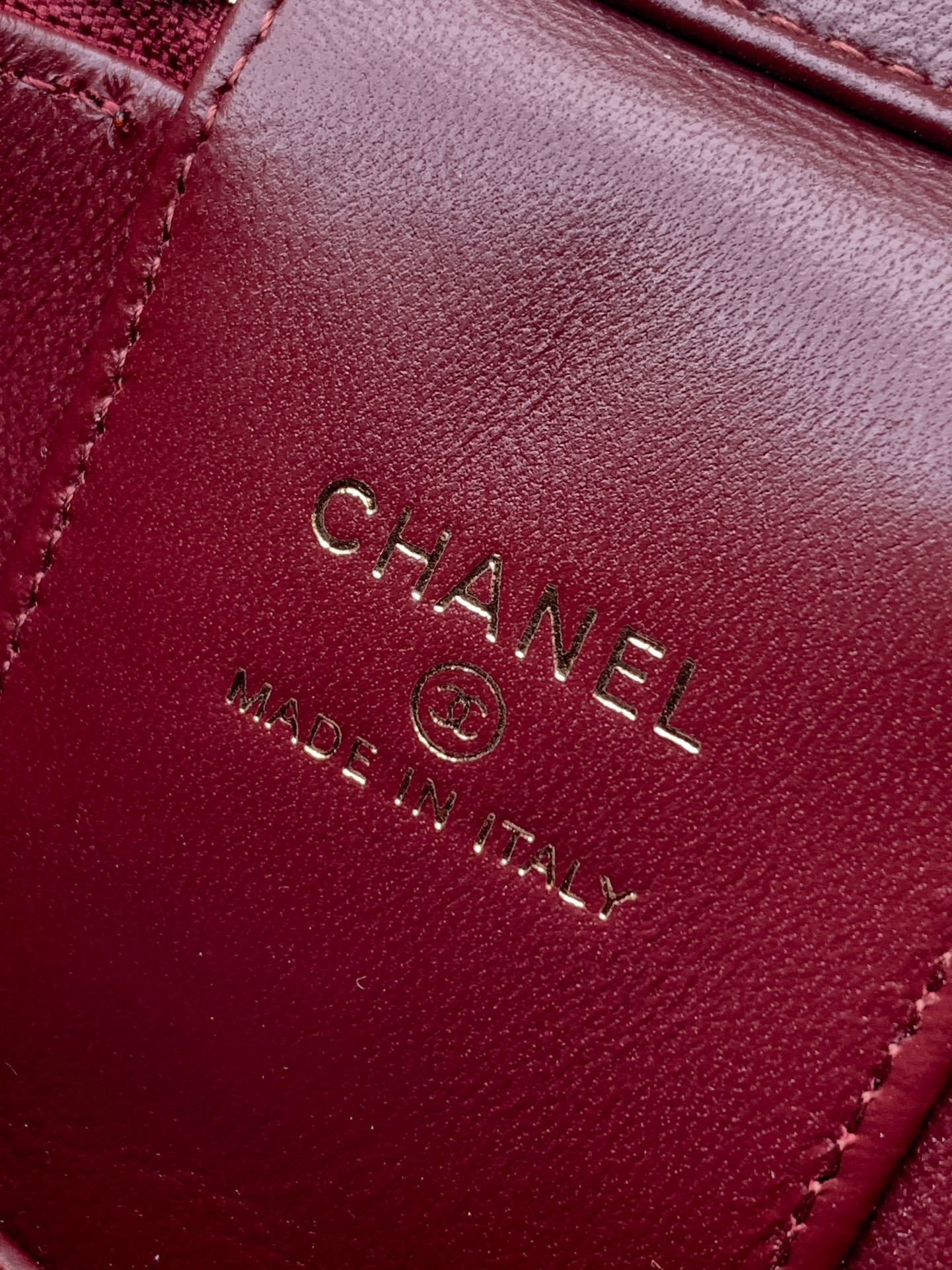 Red Chanel bag interior label with CHANEL and MADE IN ITALY text