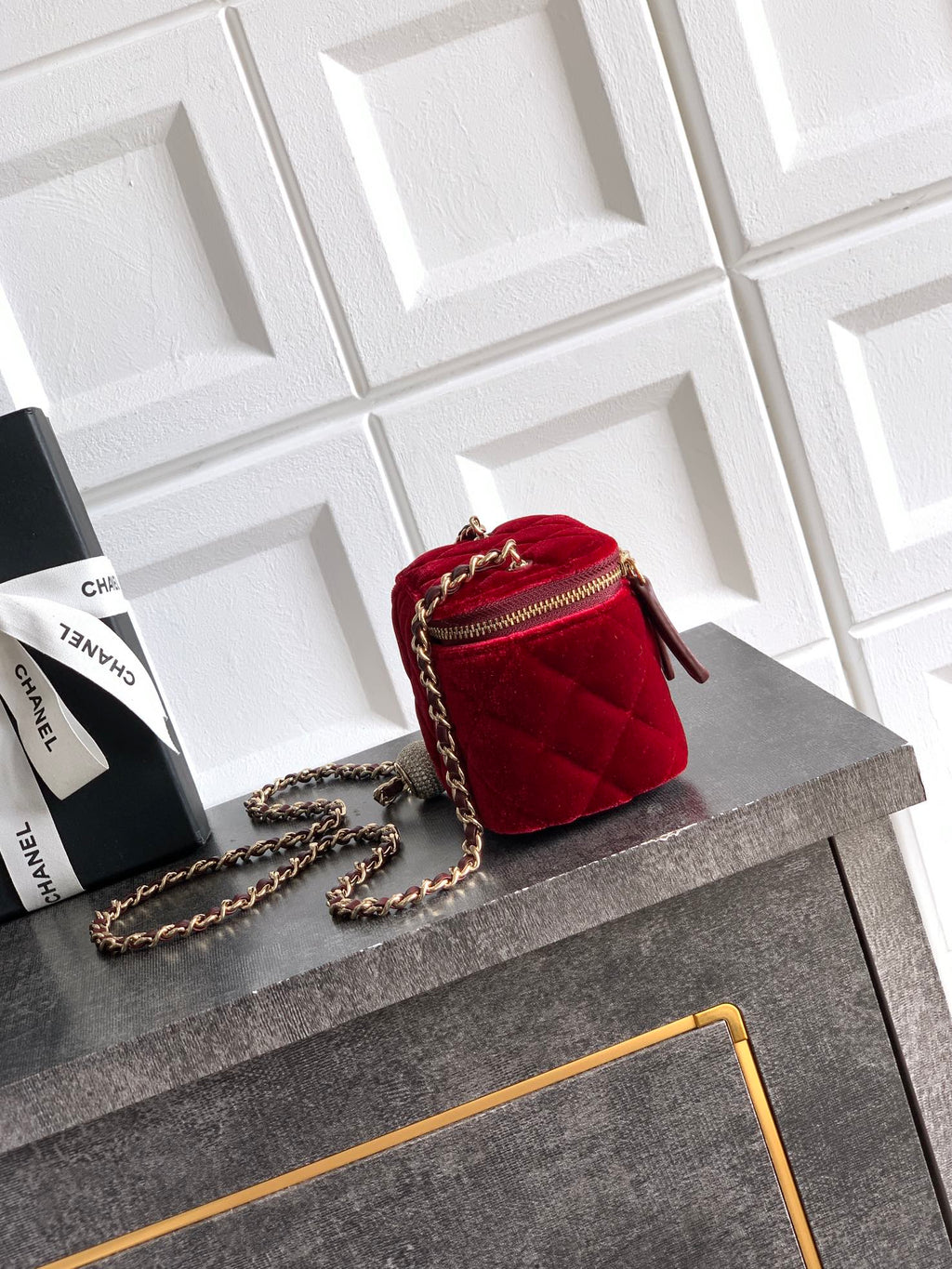 Red quilted Chanel mini bag on a chain with gold zipper and front pocket detail