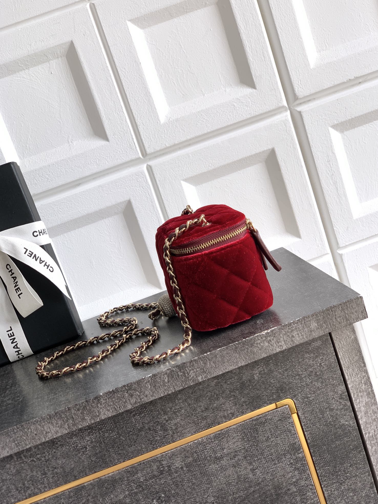 Red quilted Chanel mini bag on a chain with gold zipper and front pocket detail