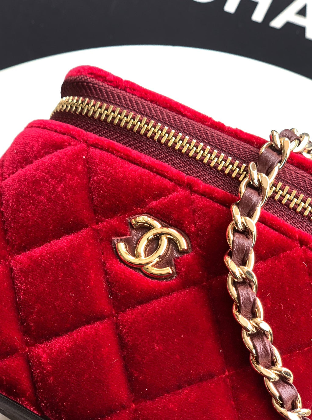 Red velvet Chanel mini bag close-up of gold zipper and chain with CC charm