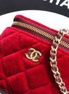 Red velvet Chanel mini bag close-up of gold zipper and chain with CC charm