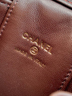 Brown leather bag exterior with stitched design and gold CC logo