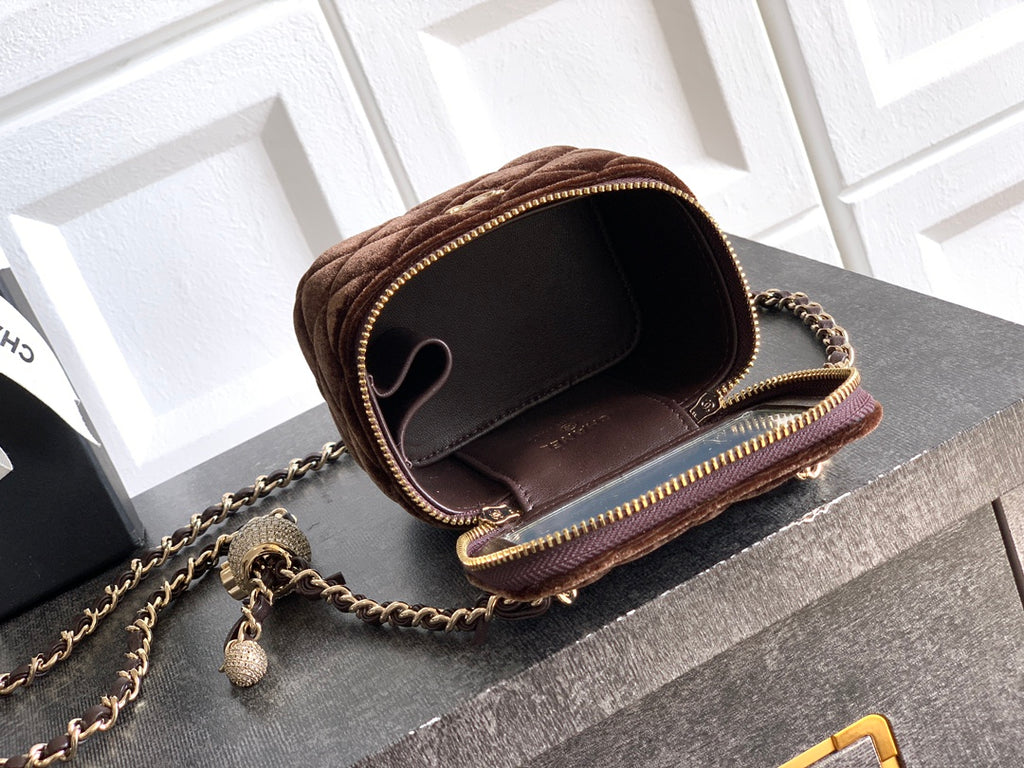 Brown mini crossbody bag open to show interior, with chain strap and zip trim
