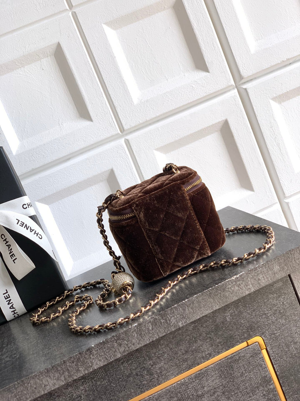 Brown quilted mini crossbody bag with chain strap and gold zip trim