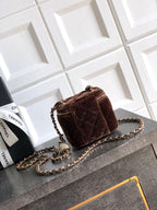 Brown quilted mini crossbody bag with chain strap and gold zip trim