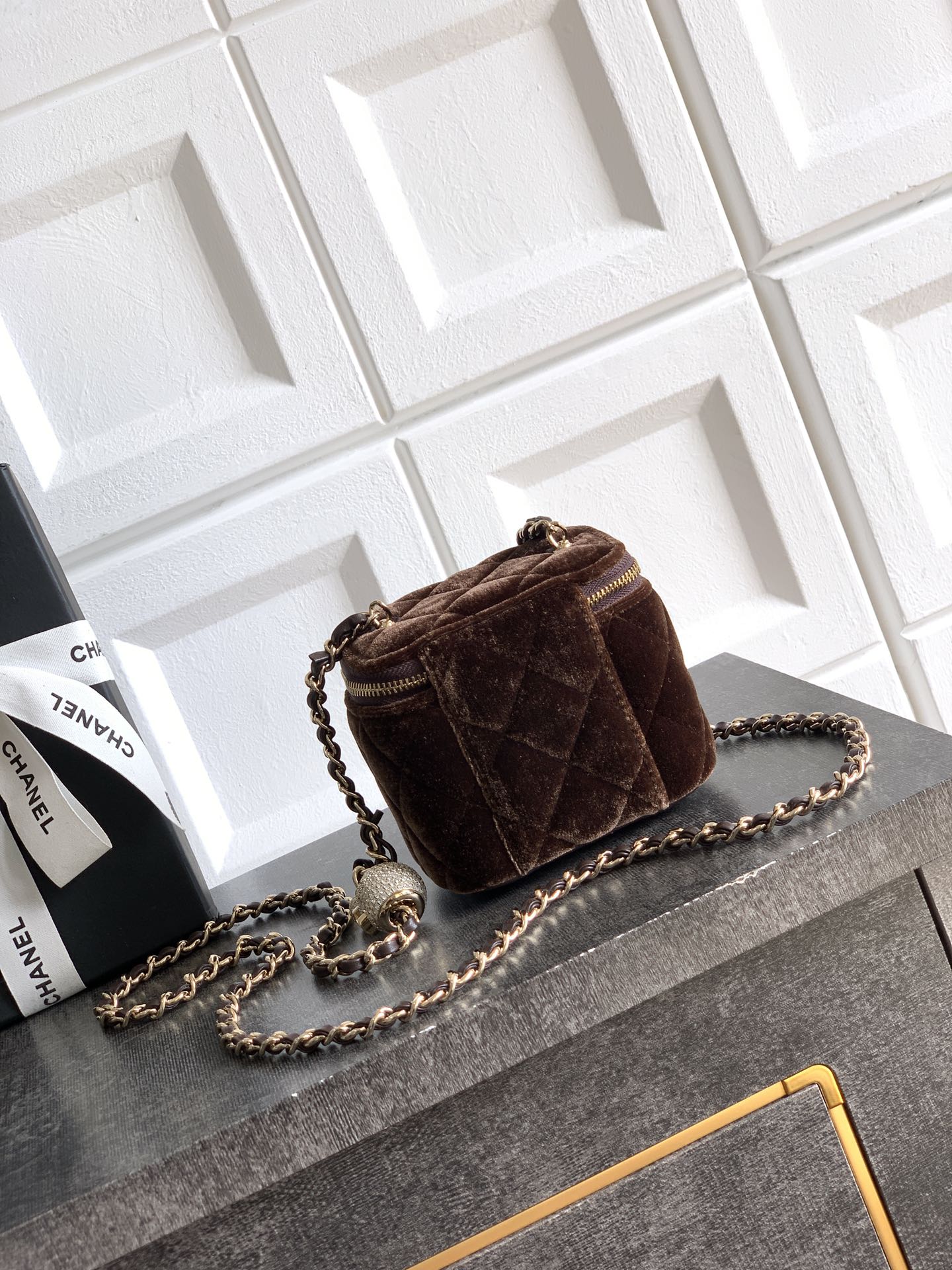 Brown quilted mini crossbody bag with chain strap and gold zip trim