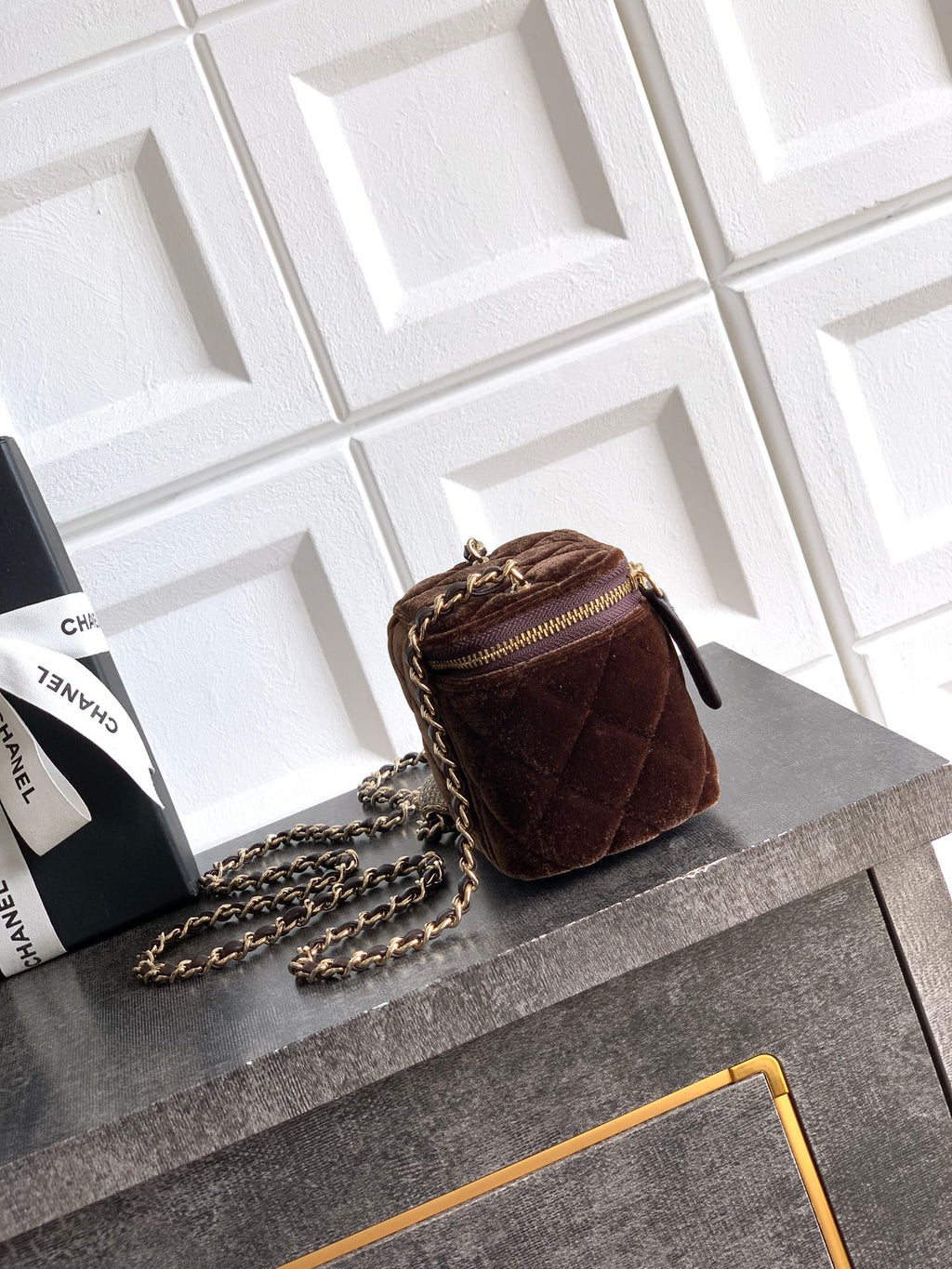 Quilted brown mini crossbody bag with gold-tone chain strap and zip closure