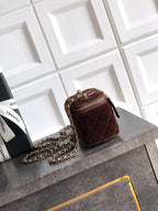 Quilted brown mini crossbody bag with gold-tone chain strap and zip closure